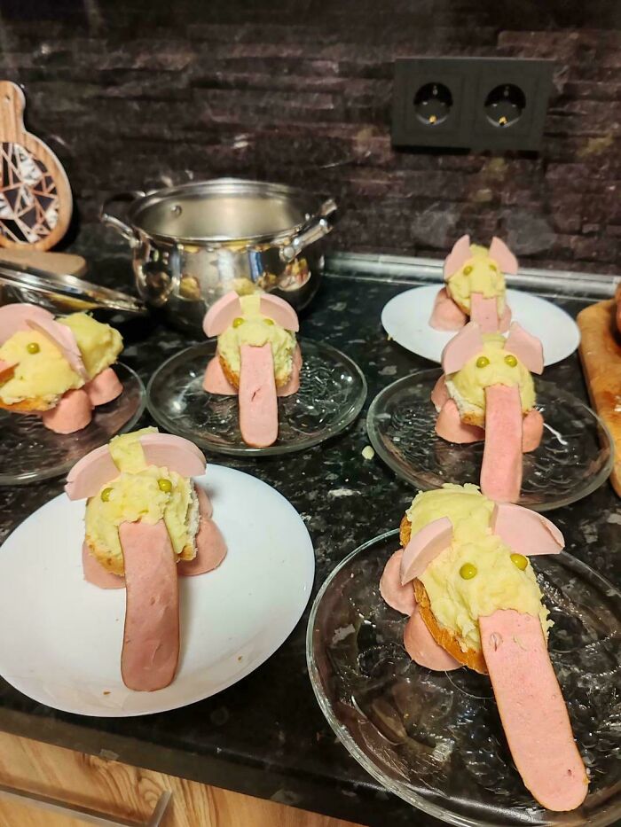 Disgusting food shaped like elephants made from sausage and mashed potatoes, served on small plates.