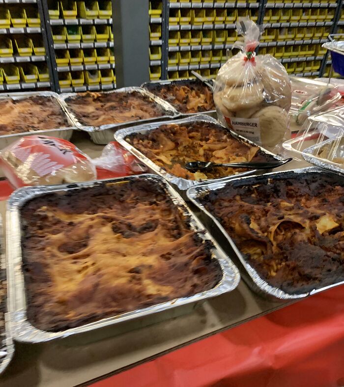Several trays of burnt, disgusting food, possibly lasagna, sitting on a table.