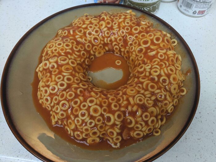 A ring-shaped mold of spaghetti rings in sauce, appearing as a disgusting food item.