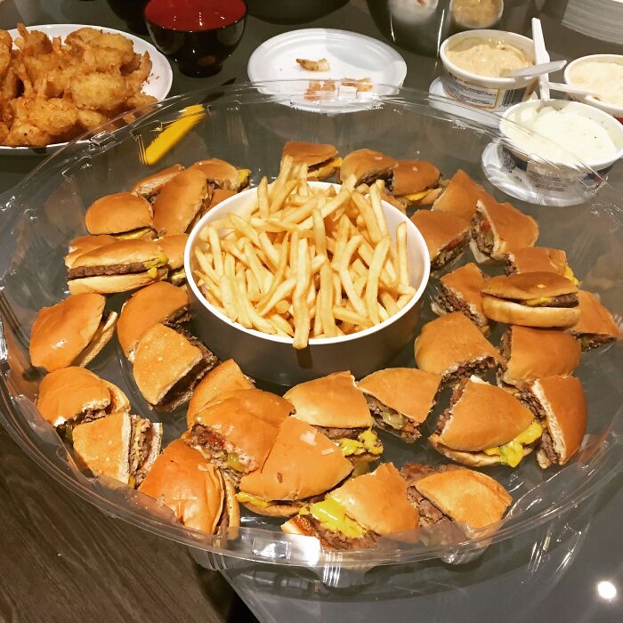A tray of disgusting food including mini burgers and fries, clearly not fit for consumption.