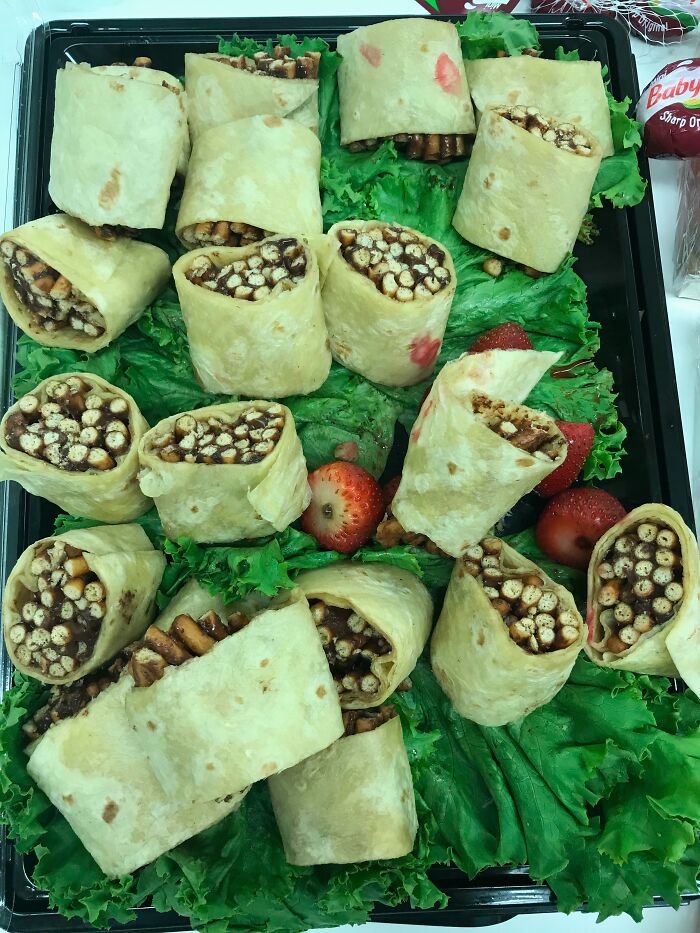 Tortilla wraps filled with cereal and pretzels, garnished with strawberries, a piece of disgusting food.