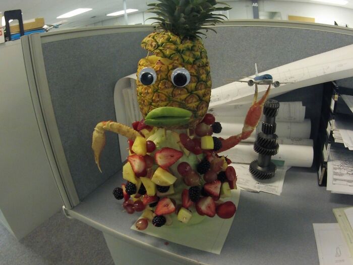 A pineapple creation with googly eyes and fruit, representing disgusting food that deserves to be publicly shamed.