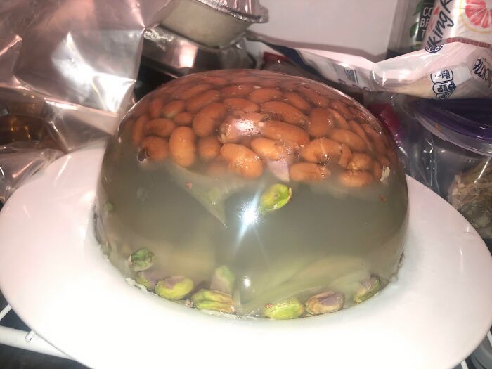A gelatin mold with baked beans and pistachios, showcasing disgusting food that deserves to be shamed.