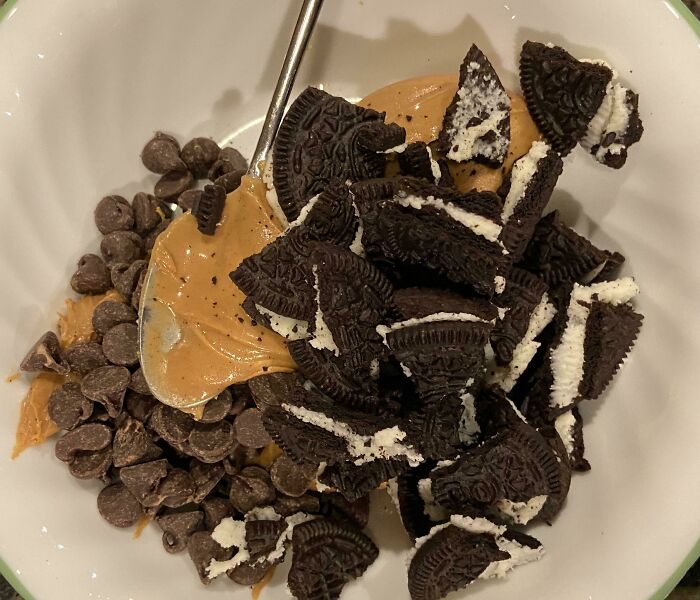 A bowl of peanut butter, chocolate chips, and crushed Oreos, illustrating a mixture of stupid vegan food ingredients.