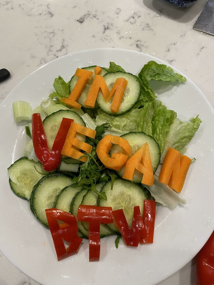 Salad with vegetables spelling out IM VEGAN BTW, a humorous example of stupid vegan food.