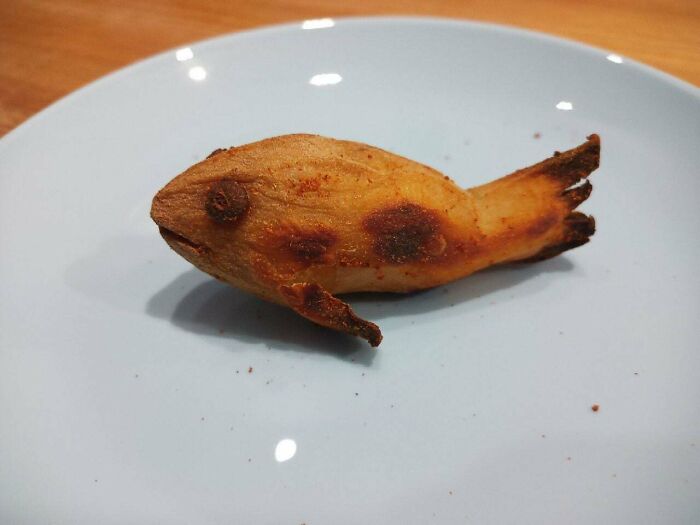 Stupid vegan food: A fish-shaped piece of fried banana, lightly browned, rests on a plain white plate.