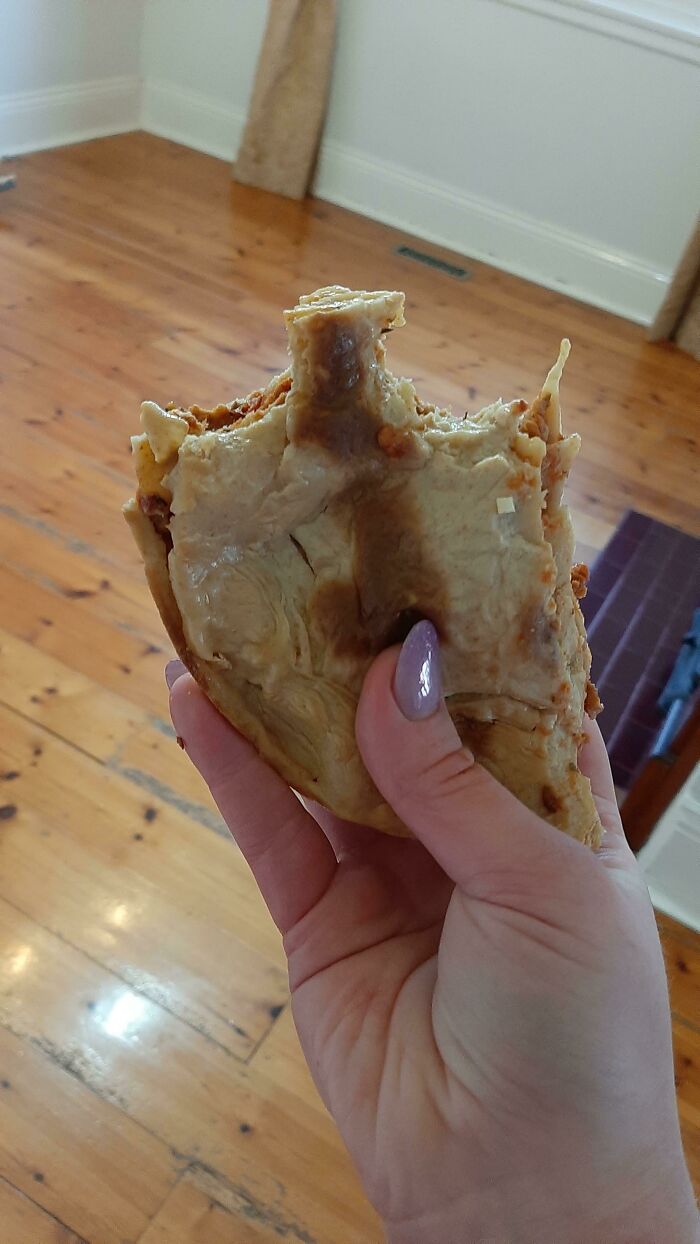 A hand holding a partially eaten, messy vegan food item, demonstrating stupid vegan food.