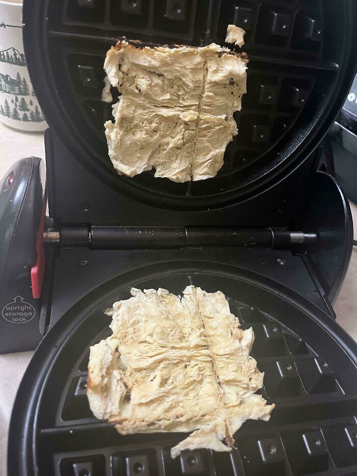 A burnt, mangled piece of vegan food inside a waffle maker, deserving public shaming for its unappetizing appearance.