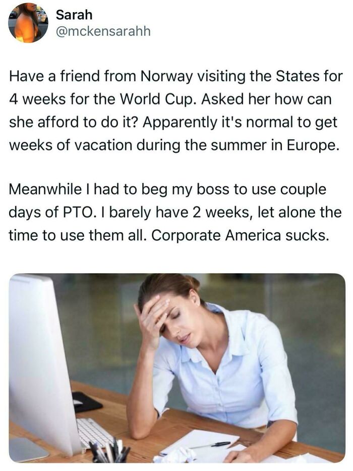 A woman with her head in her hands at a desk, frustrated with work and limited vacation, a recruiting hell post.