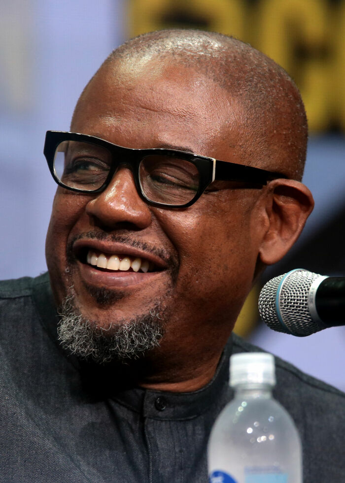 Forest Whitaker smiling at an event, showcasing his career highlights and engaging with the audience.