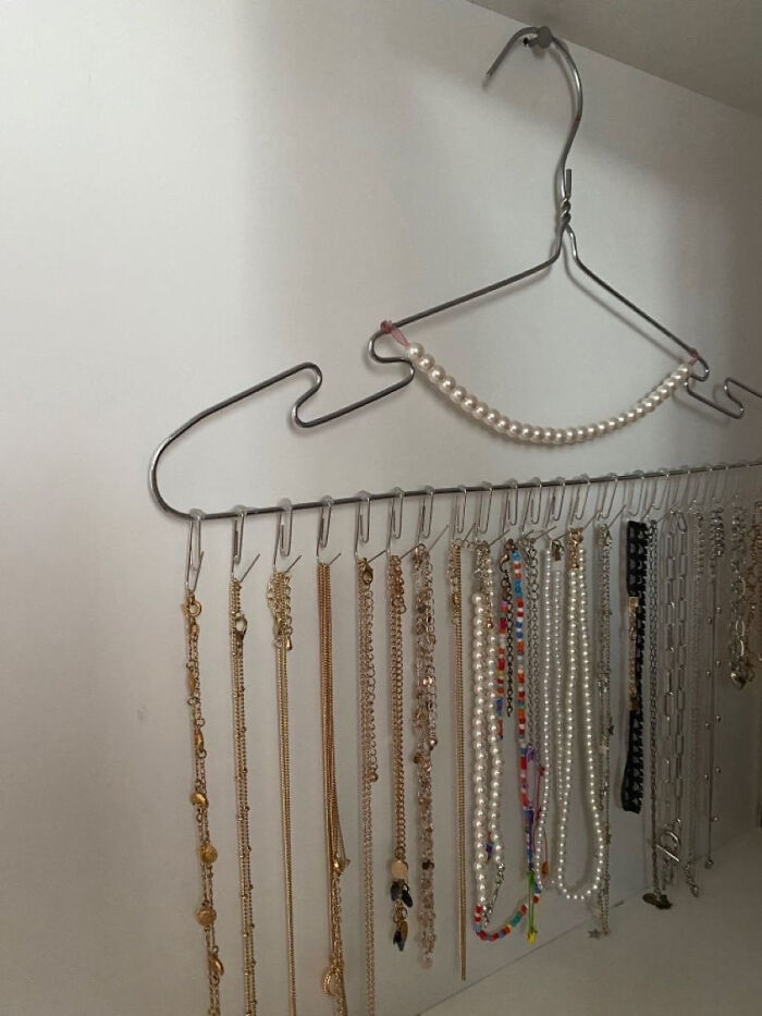 A hanger repurposed to organize necklaces, a creative home DIY project for small spaces.