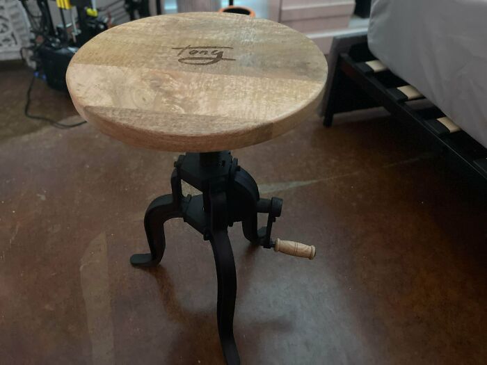 A close-up of a rustic wooden stool with an adjustable crank mechanism, showcasing a creative home DIY project.