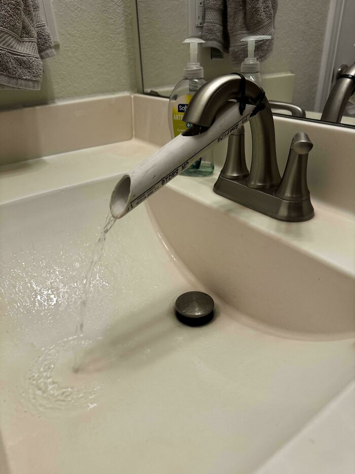 A creative home DIY project: a temporary sink faucet made from a PVC pipe, demonstrating resourcefulness.