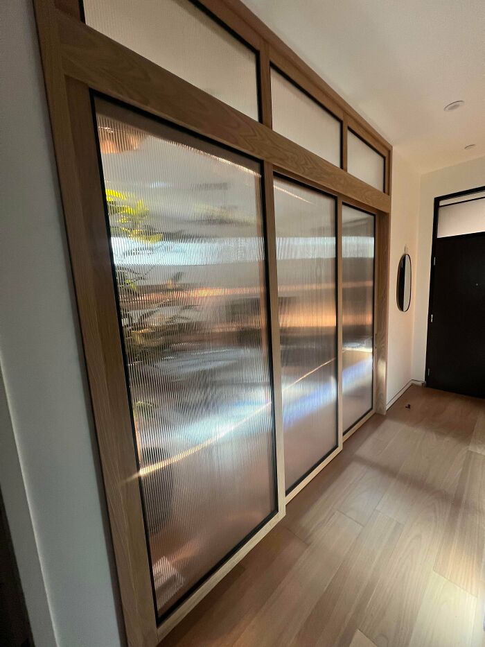 An entryway with new sliding glass panels, a creative home DIY project offering a modern, textured look.