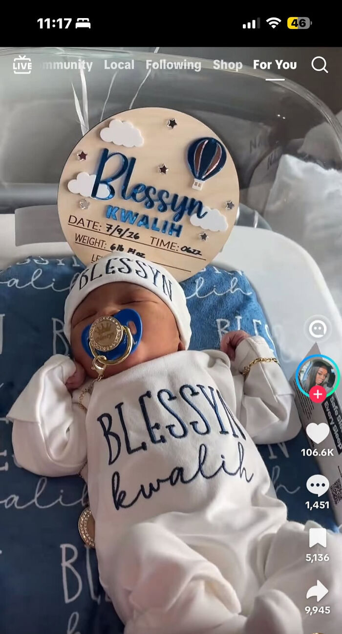 A baby wearing a onesie with the unusual name Blessyn Kwali, a name parents might consider less boring.