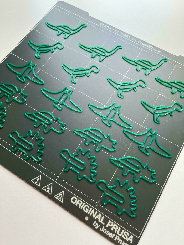 Green dinosaur paper clips printed with 3D printers, useful and cool items.