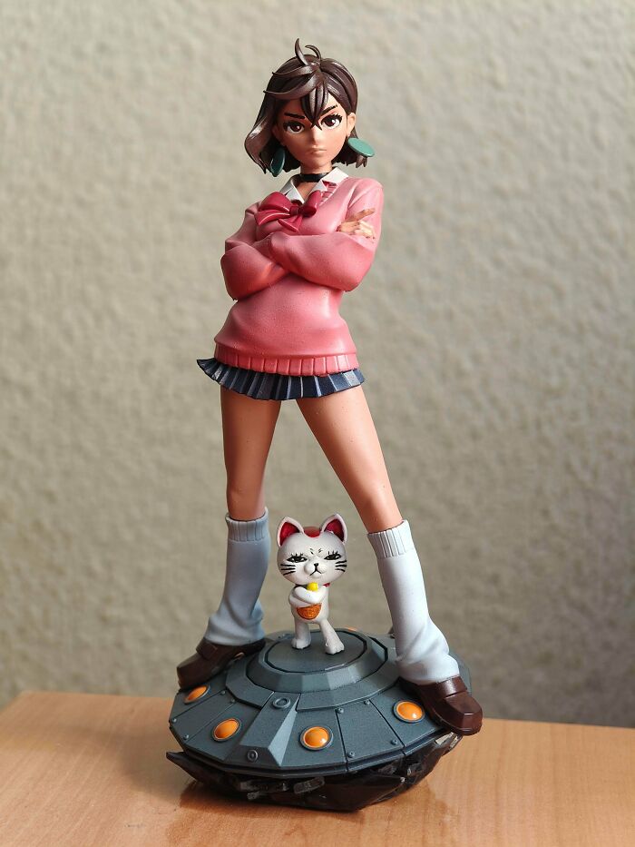 A detailed 3D printed anime-style female figurine standing on a circular base with a small cat figure.