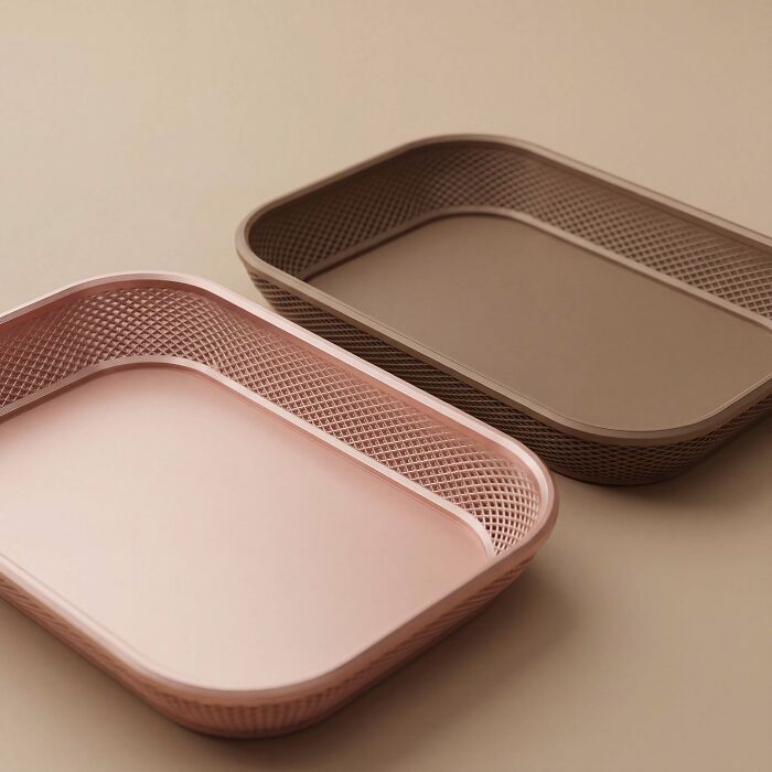 Two sleek, rectangular 3D printed trays in rose gold and brown, illustrating useful things people printed with 3D printers.