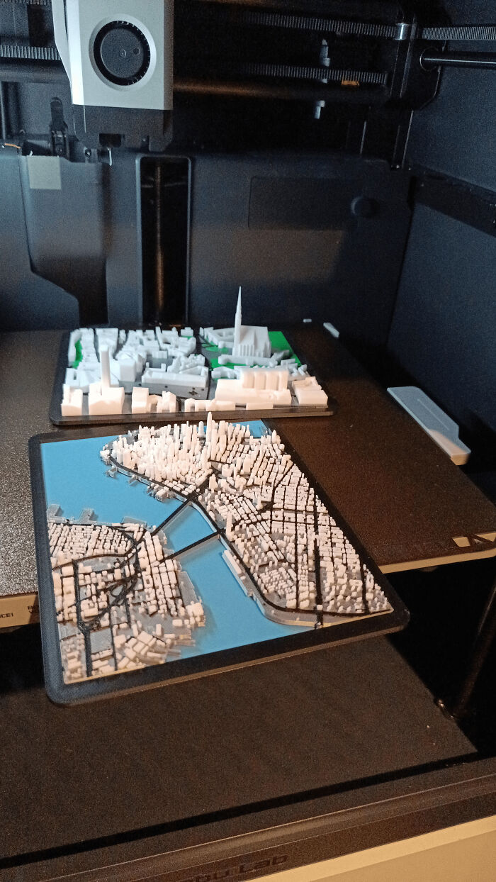 Detailed 3D printed city models on a printer bed, showcasing cool and useful things people printed with their 3D printers.