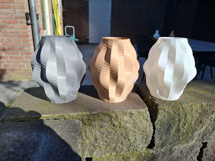 Three cool 3D printed vases in gray, tan, and white, showcasing useful 3D printers creativity.