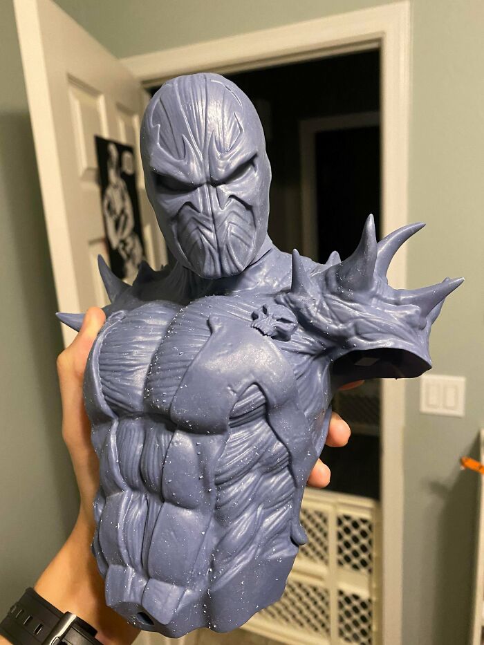 A hand holding a 3D printed Spawn bust, an example of cool things people printed with their 3D printers.