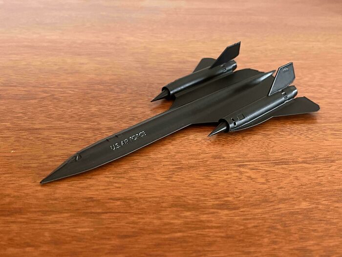A detailed black model of a U.S. Air Force jet on a wooden table, printed with a 3D printer.