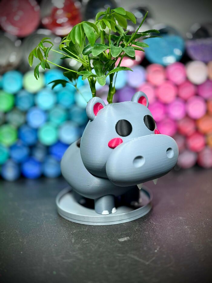 A cute grey hippopotamus planter with a small plant, one of many cool things people printed with 3D printers.