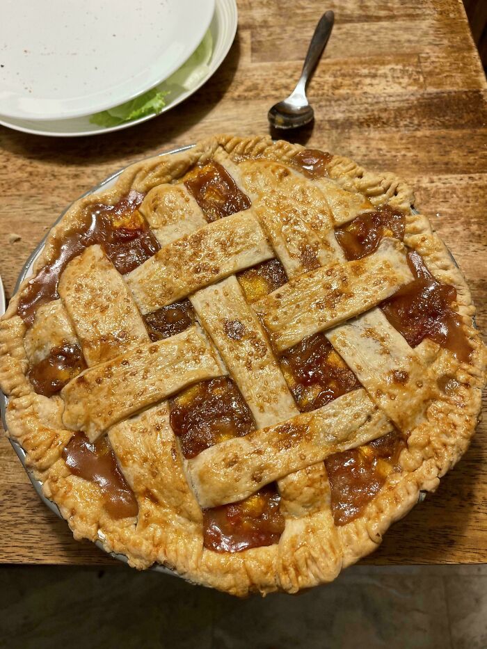 A freshly baked pie with a lattice crust and a glistening fruit filling, demonstrating the delicious and amazing treats from bakers.