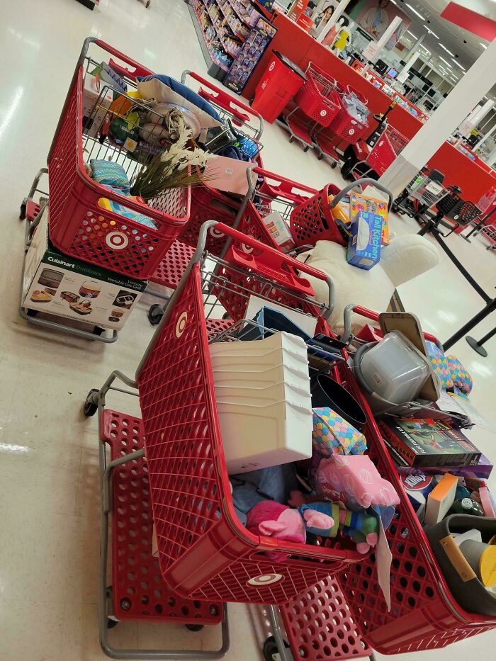 Service industry workers face overflowing shopping carts left in an aisle, highlighting job challenges.