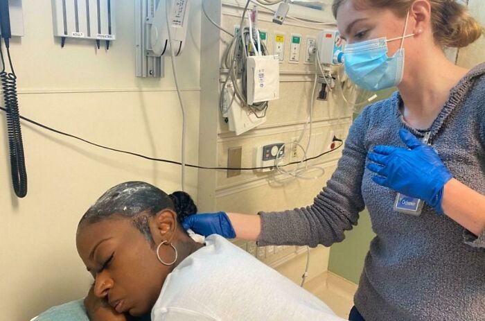 A woman with white powder on her head receiving care from a nurse in a hospital, illustrating unfortunate displays of stupidity.