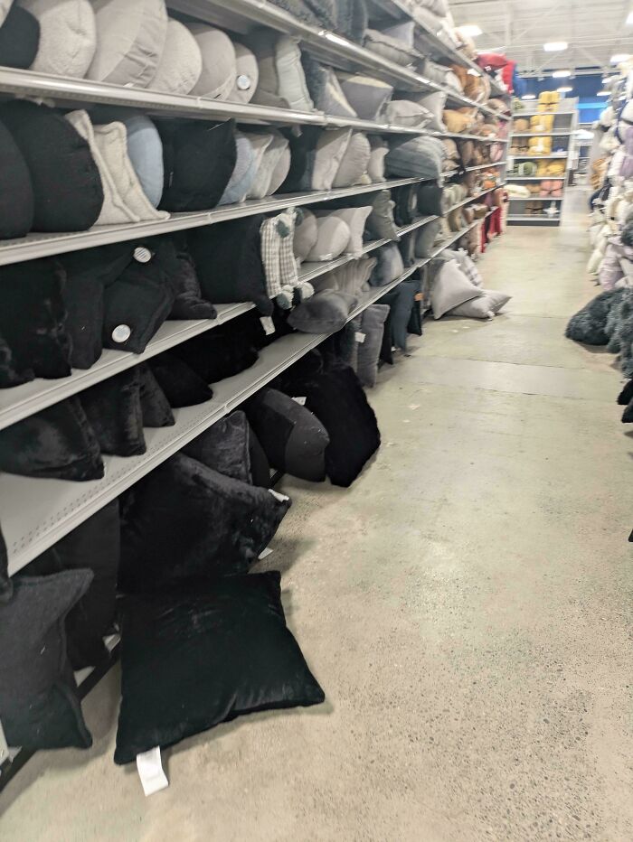 Pillows knocked off shelves onto the floor in a retail store, illustrating the frustrations of service industry workers.