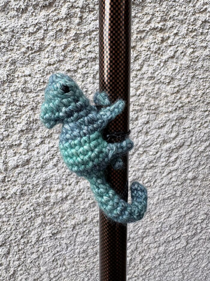 Small blue crochet seahorse wrapped around a pole