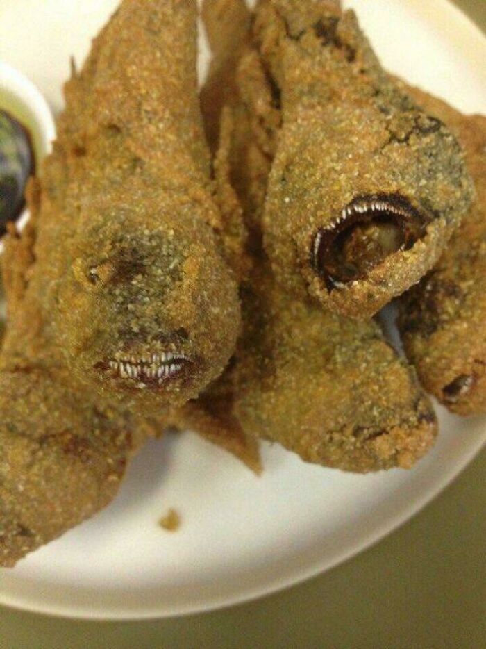 Deep-fried fish with their mouths open, revealing sharp teeth, a creepy and confusing meal.
