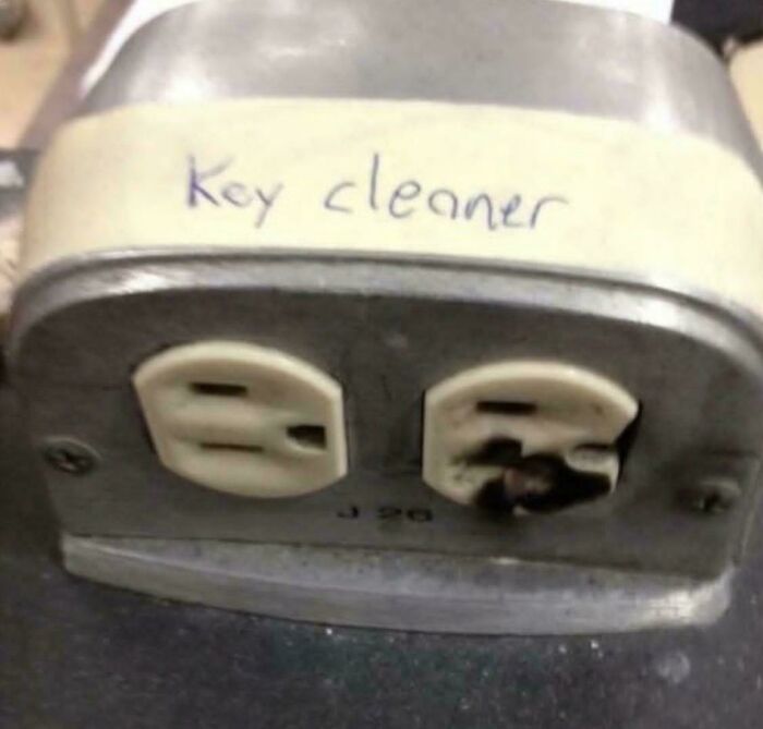 A burnt electrical outlet labeled 'Key cleaner,' a confusing and dangerous example of creepy images.