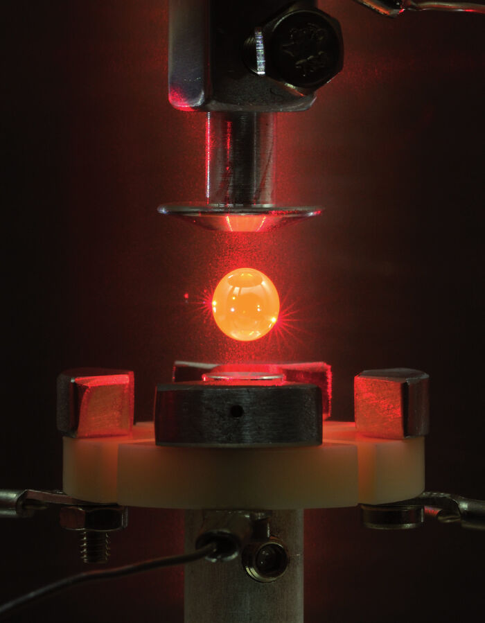 Satisfying and genius technologies: A glowing sphere levitating between metal components, showcasing advanced physics.
