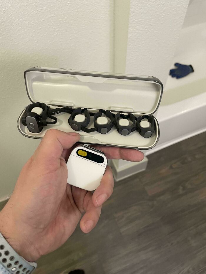 Satisfying and genius technologies: A person holding a white modern earbud case and a set of bone conduction headphones.