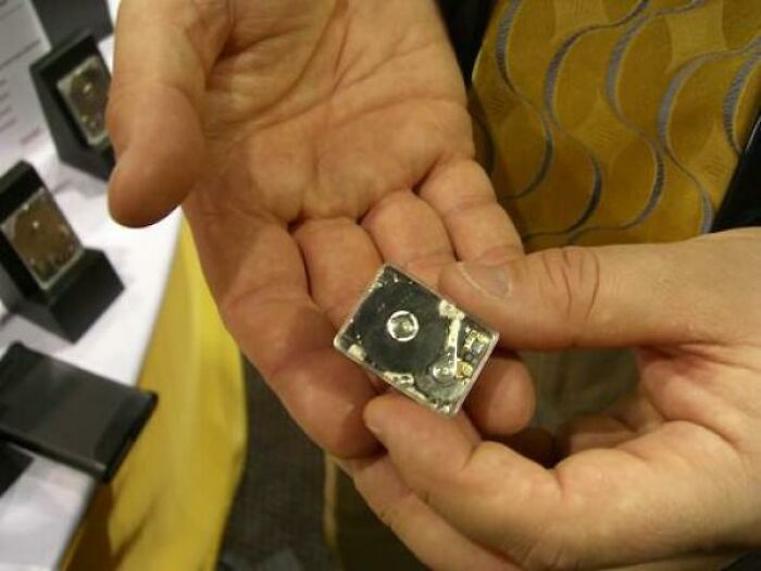 A person holding a tiny, intricate hard drive, emphasizing the miniaturization in genius technologies that make everyday life easier.