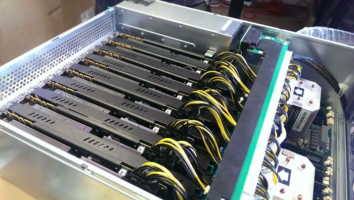 Server rack filled with multiple GPU cards and their power cables, representing powerful satisfying technologies.