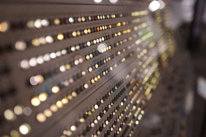 Close-up of a control panel with many illuminated lights, showcasing satisfying technologies.
