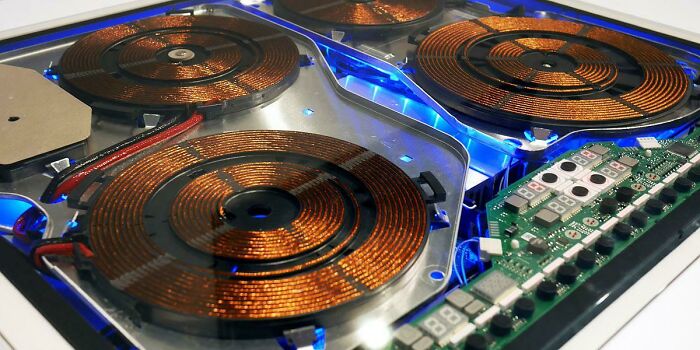 Internal view of an induction cooktop with glowing blue lights, demonstrating satisfying technologies.
