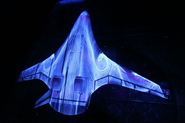 Blue light trails on a drone model showcasing genius technologies and aerodynamic principles.