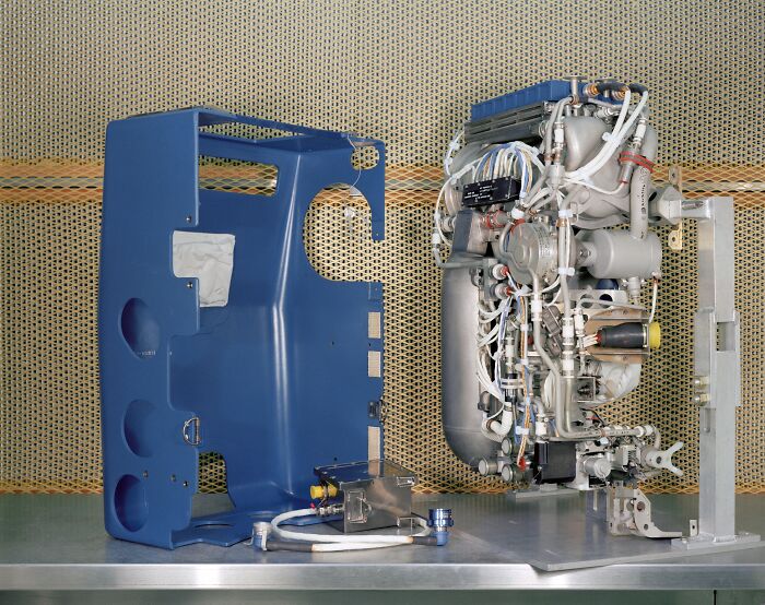 An exposed engine, demonstrating genius technologies, next to its blue protective casing, revealing intricate components.