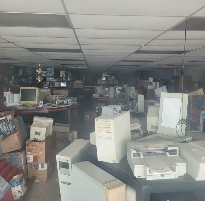 An abandoned store filled with old computer equipment, highlighting past technologies that made everyday life easier.