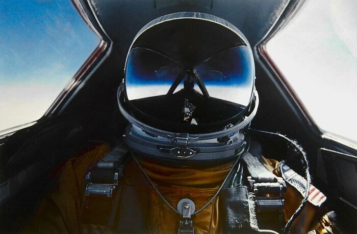 Pilot in a cockpit, wearing a helmet, showcasing advanced technologies that make everyday life easier and safer.