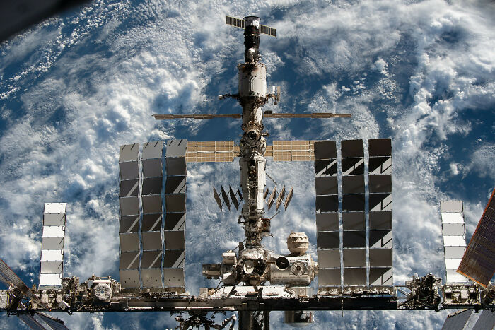 The International Space Station orbiting Earth, an example of genius technologies improving everyday life.