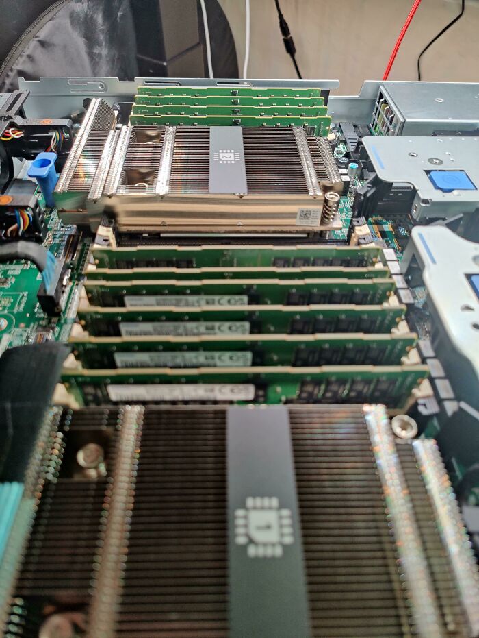 An open computer server reveals rows of RAM modules and heat sinks, highlighting genius technologies within.