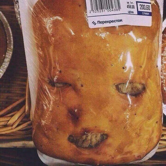 A baked good in plastic packaging with facial features resembling a creepy and confusing image of a baby.
