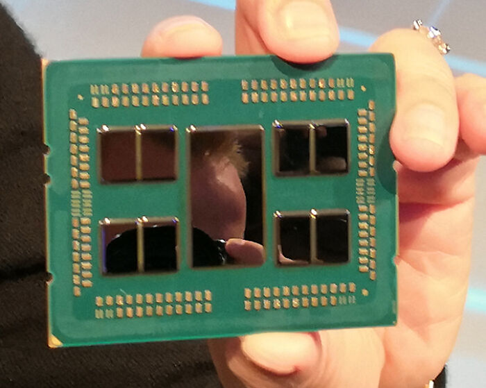 A hand holding a computer chip, representing genius technologies that make everyday life easier and power our digital world.