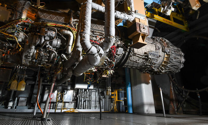 A complex jet engine suspended, highlighting the genius technologies that make everyday life easier in aviation.