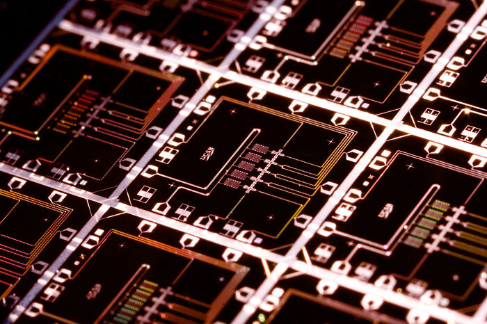 Satisfying and genius technologies: A close-up of illuminated circuit board patterns.